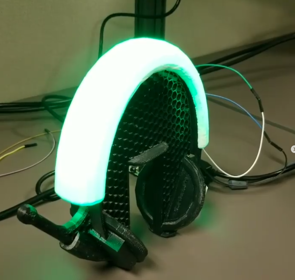 Illuminated 3D-printed AR prototype glowing green on the bench