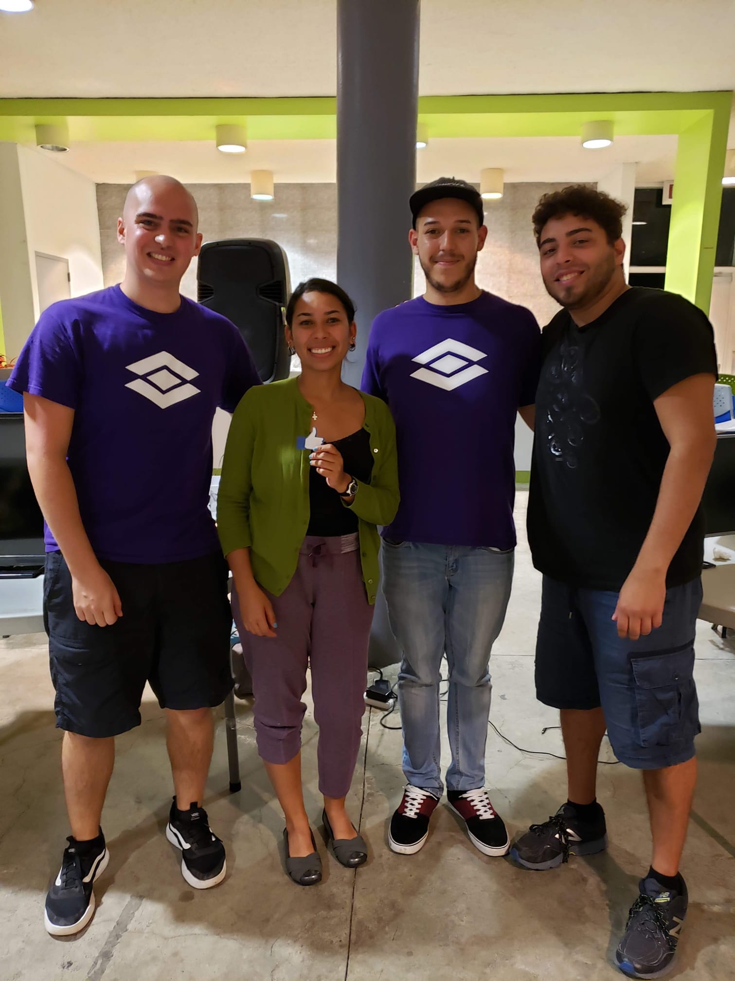 Two Visionary staff in purple club shirts with two hackathon winners