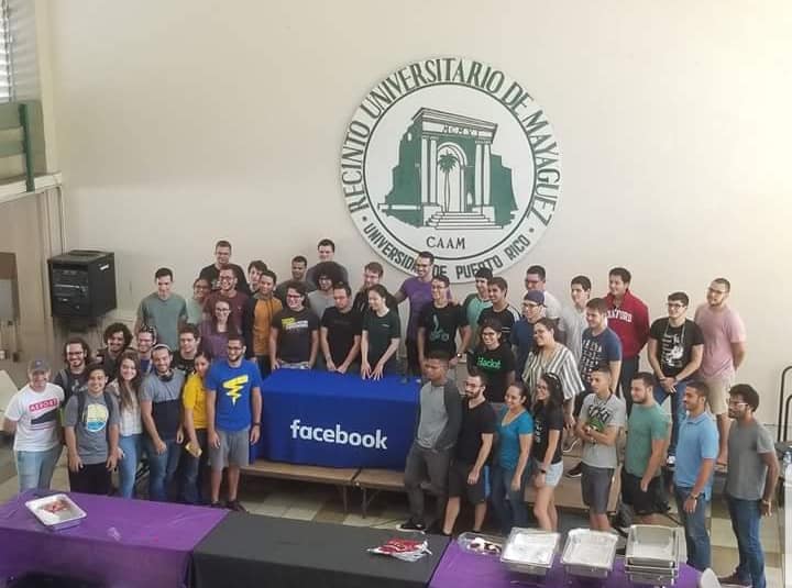 Visionary members gathered around a Facebook-branded table under the UPR Mayagüez seal